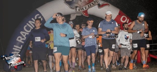 Runners at start line under Trail Racing Over Texas inflatable arch